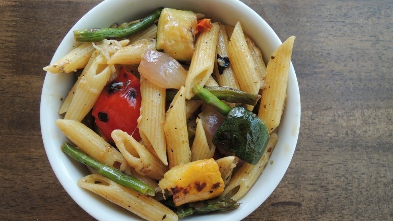 pasta dish filled with fresh produce in bowl on wooden table