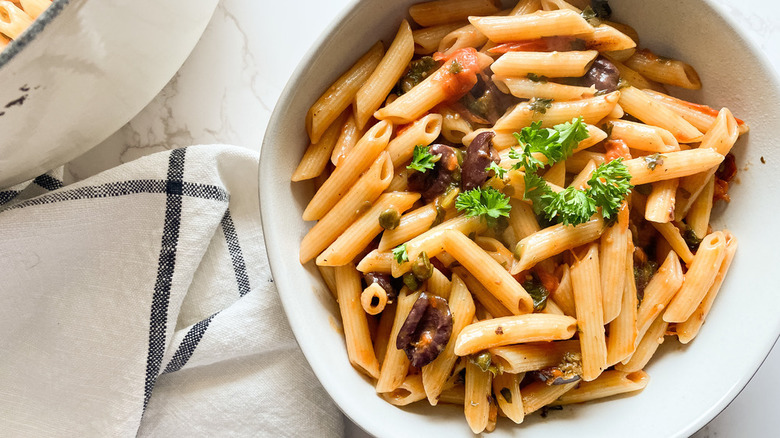 bowl of puttanesca with grape tomatoes, olives, and anchovies