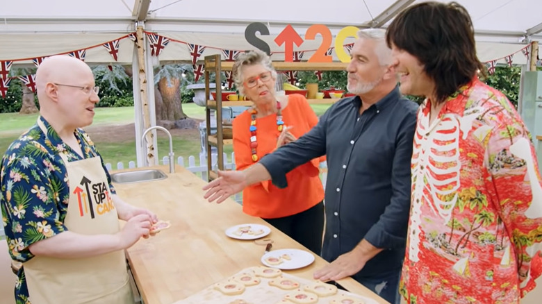 Paul hollywood offering a handshake to matt lucas