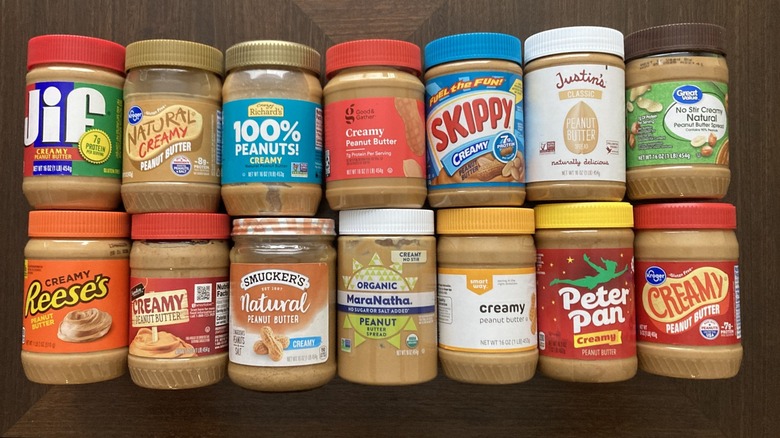 various brands of peanut butter on wooden background