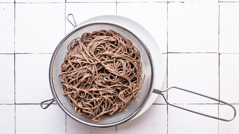 cooked soba noodles in strainer.
