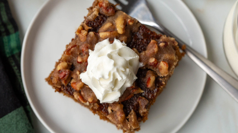 gingerbread pecan cake slice with whipped cream