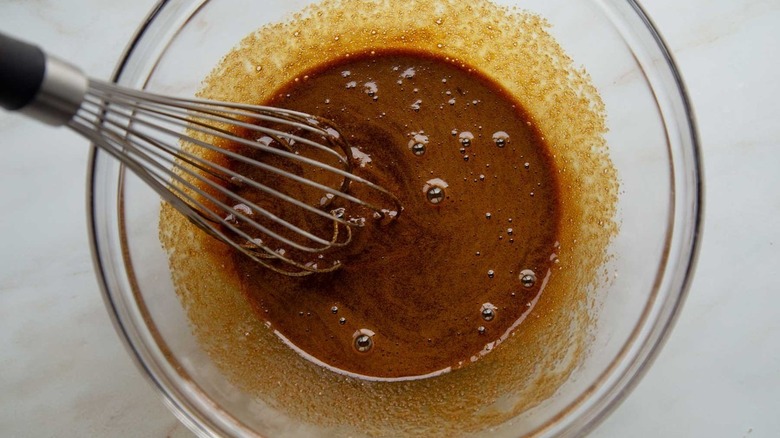 molasses mixture in clear bowl with whisk