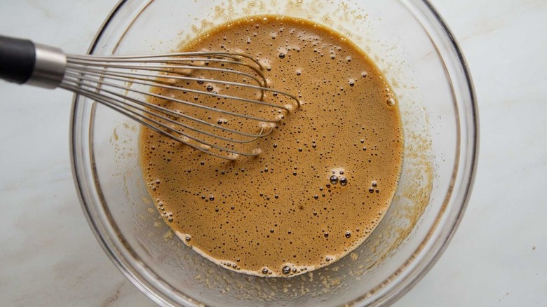 molasses mixture in clear bowl with whisk