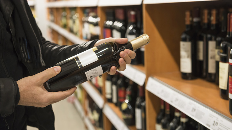 person holding bottle of wine