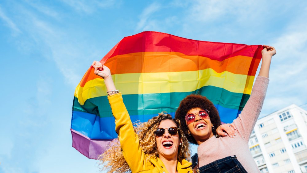 Two women holding up rainbow flag