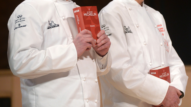 Chefs holding 2018 versions of the physical Michelin guide