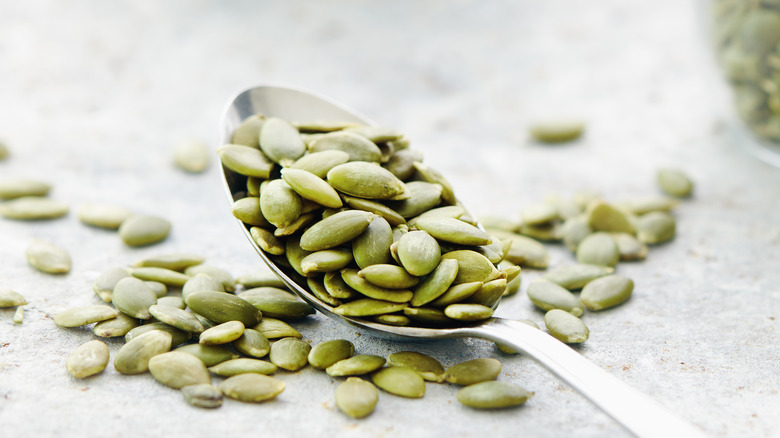 Green pepitas on a spoon