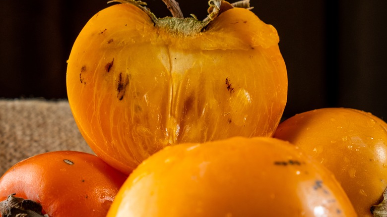 persimmons against black background