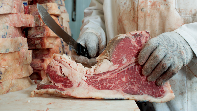 butcher holding a cut of beef