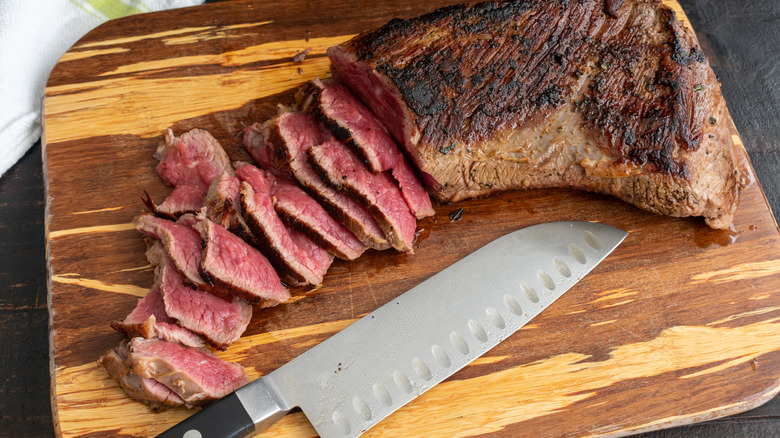 cutting board with sliced seared steak