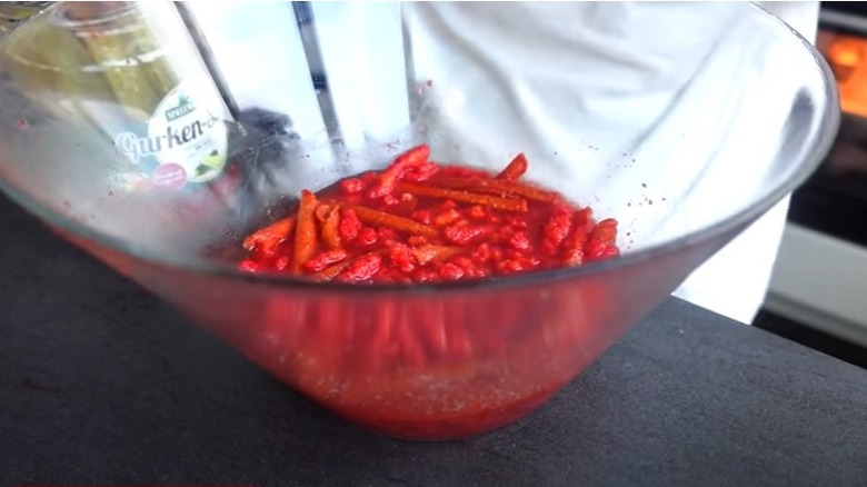 pickle juice in bowl with Hot Cheetos