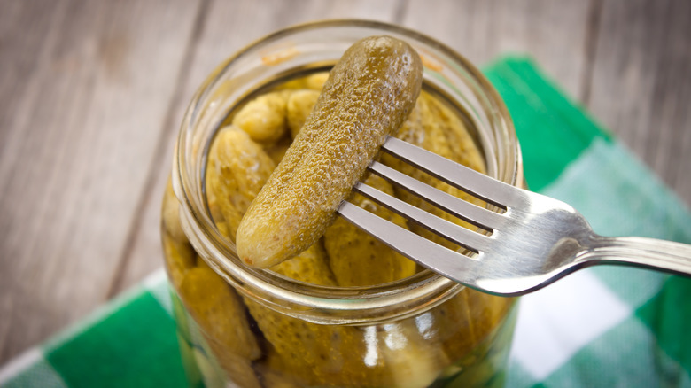 fork lifting pickle out of jar