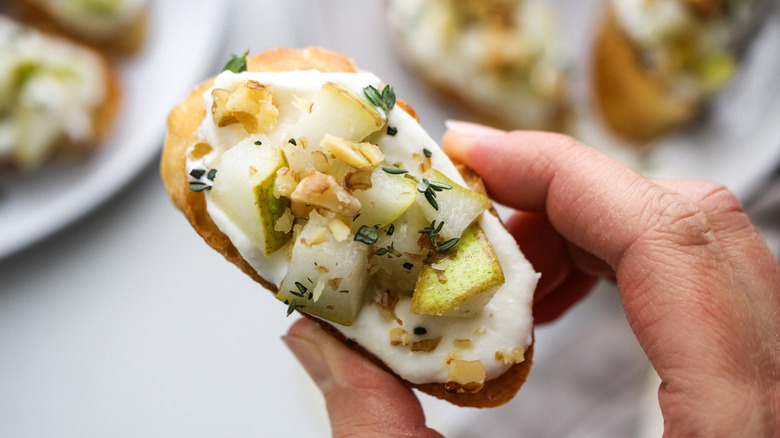 hand holding pear crostini