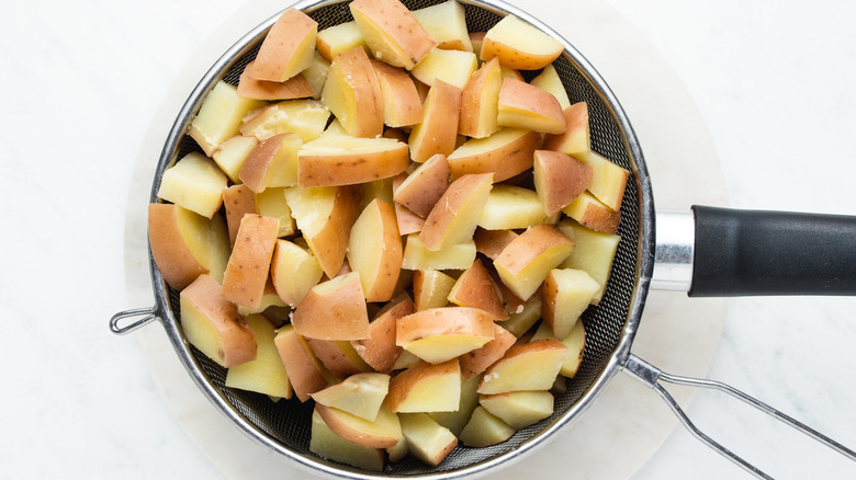 sliced potatoes in colander