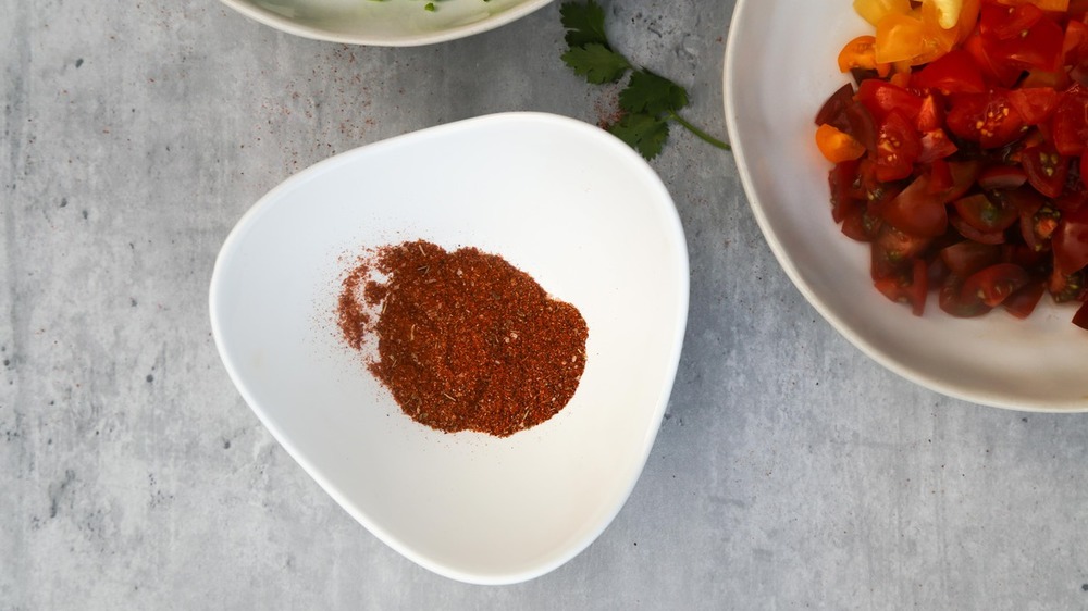 Tomatoes, poblano, cilantro, taco seasoning on table for pico de gallo recipe