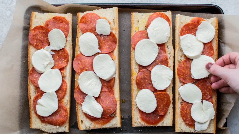 adding cheese to pizza bread