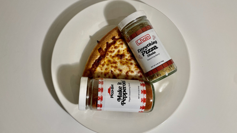 Seasonings and slice of pizza on plate