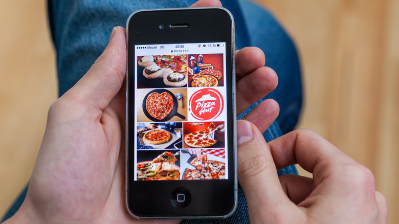 Person holds Pizza Hut app