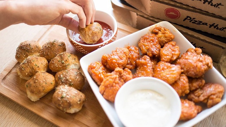 Person dunking a garlic knot