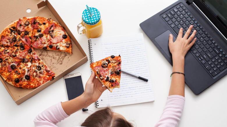 using laptop while eating pizza