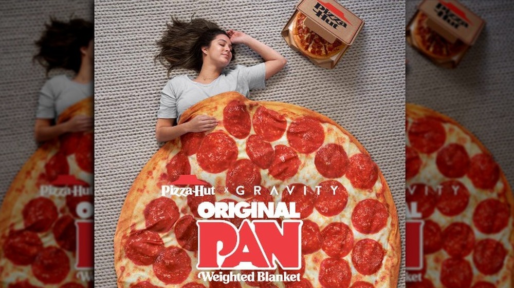 woman laying under the pizza hut weighted blanket