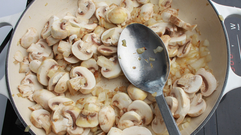 spoon in pan with mushrooms