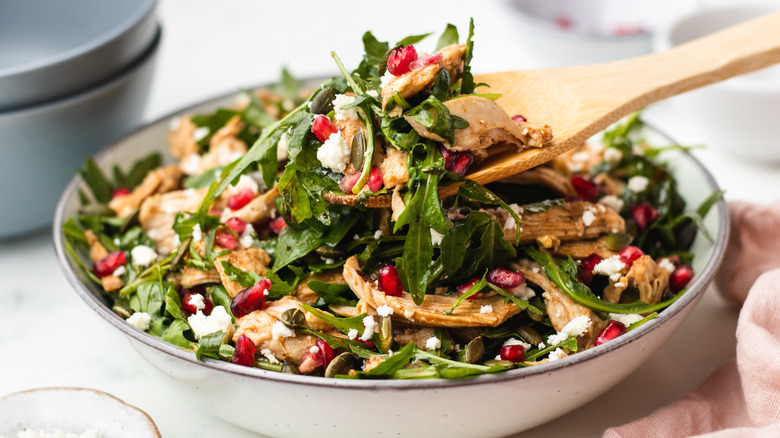 Chicken salad being spooned out of a bowl