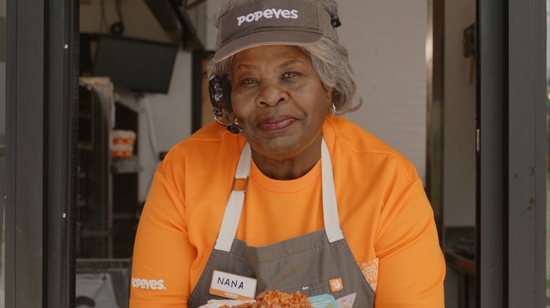 Woman at Popeyes drive-thru window.