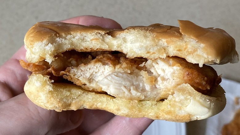 Half-eaten Chick-fil-A sandwich in hand