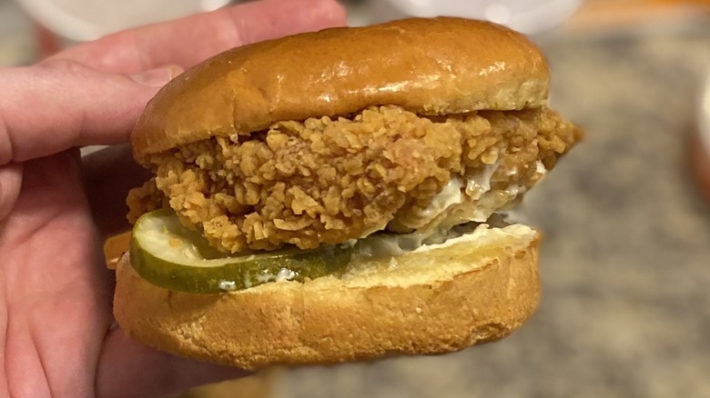 Hand holding Popeye's sandwich