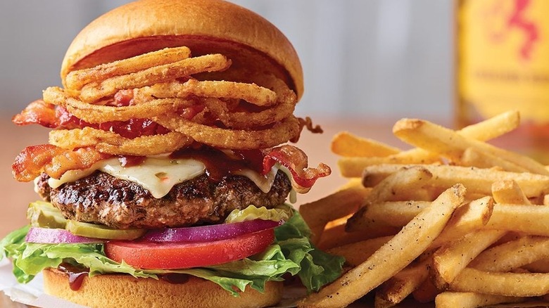 burger with onion rings, bacon, pickles, red onion, tomatoes, lettuce, special sauce pepper jack cheese, brioche bun and seasoned fries