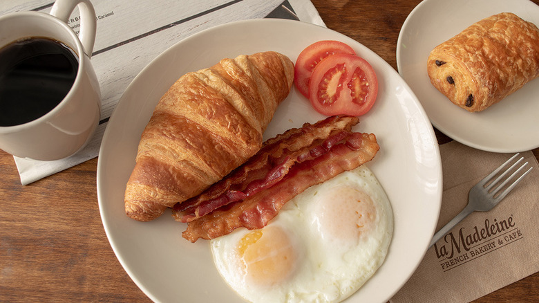 eggs bacon and croissant on table