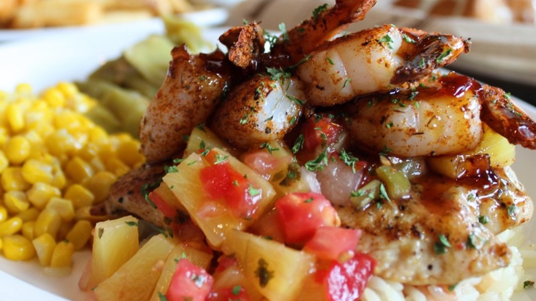 Key West Chicken & Shrimp on white rice is served with corn on the side.