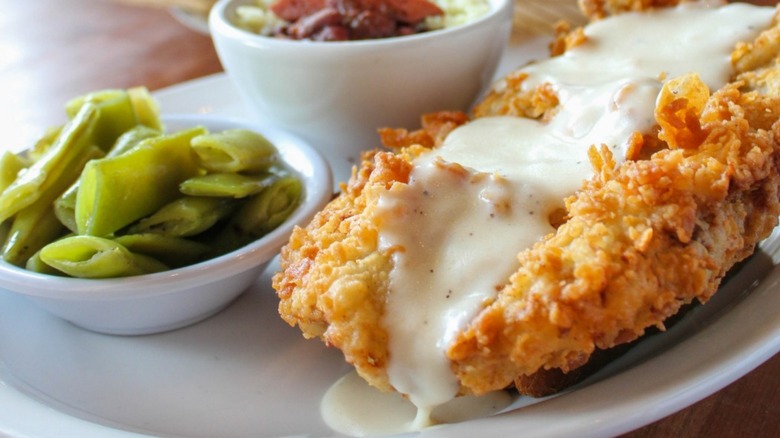 Cheddar's country fried chicken is covered in gravy and served with sides.