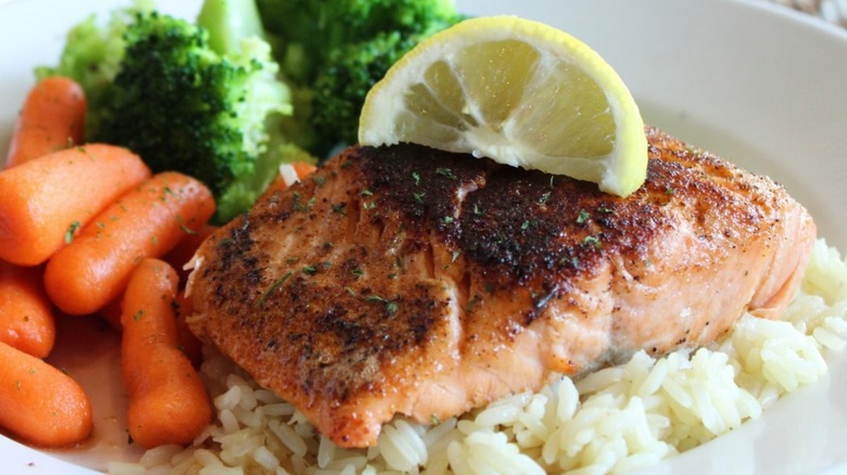 Cheddar's salmon is served with a slice of lemon and two sides.