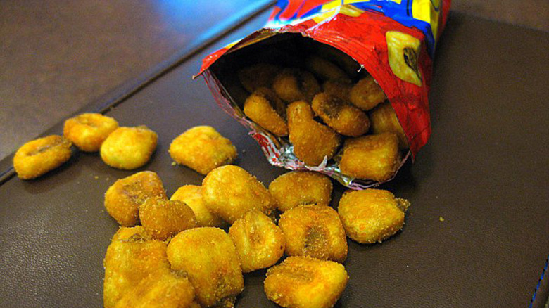 bag of BBQ flavored CornNuts open with yellow roasted CornNuts spilled out 