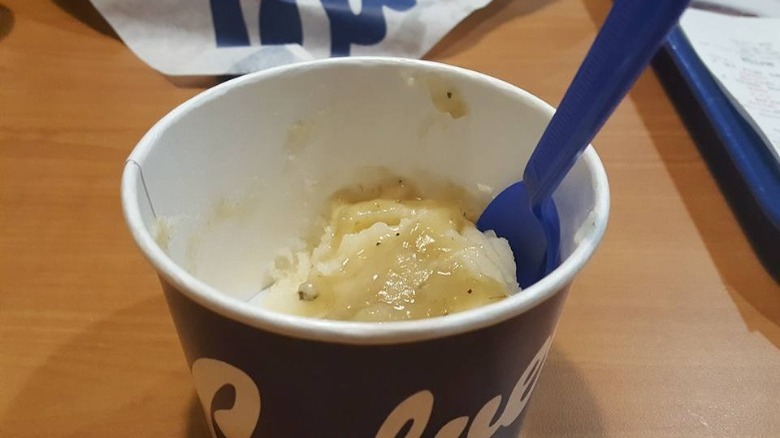 Cup of Culver's Mashed Potatoes & Gravy with a plastic spoon