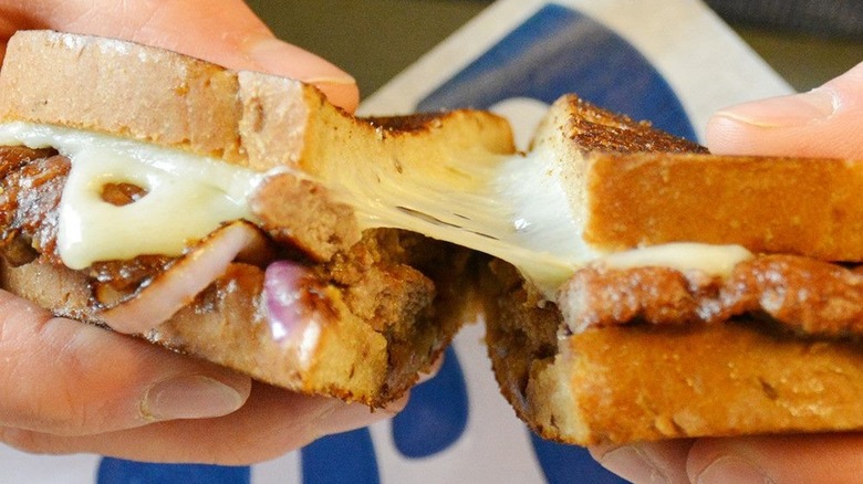 Holding Culver's Wisconsin Swiss Melt sandwich