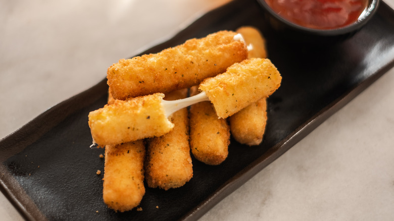 mozzarella sticks on black platter