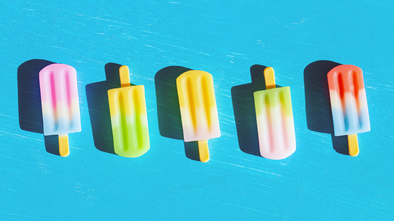 Multicolored popsicles on blue background