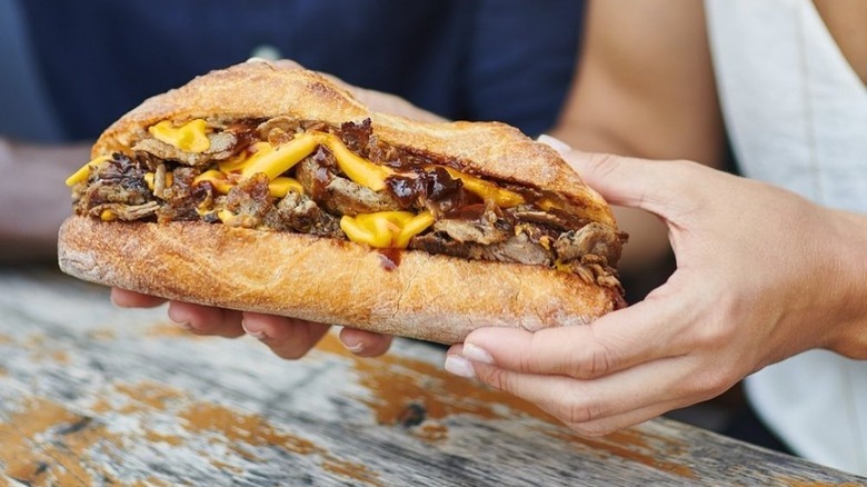 holding cheesesteak ribeye american cheese 