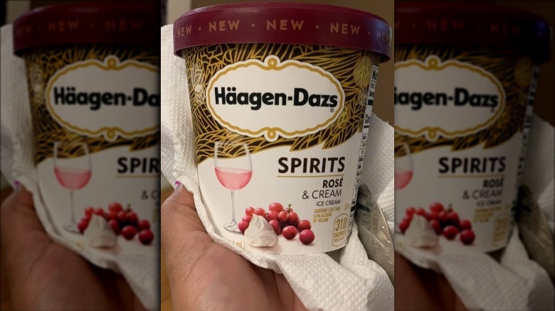 Someone holding container of Haagen-Dazs Rosé & Cream Ice Cream