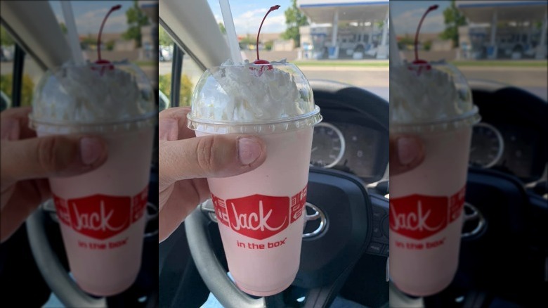 Someone holding Jack in the Box Strawberry Shake in the car