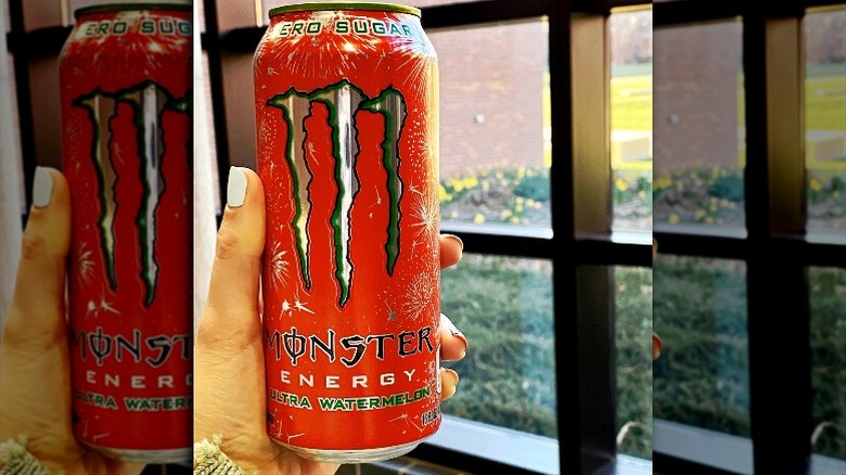 Woman holding can of Monster Energy's Zero-Sugar Ultra Watermelon by a window