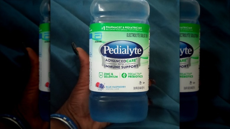 Someone holding bottle of Blue Raspberry Pedialyte AdvancedCare