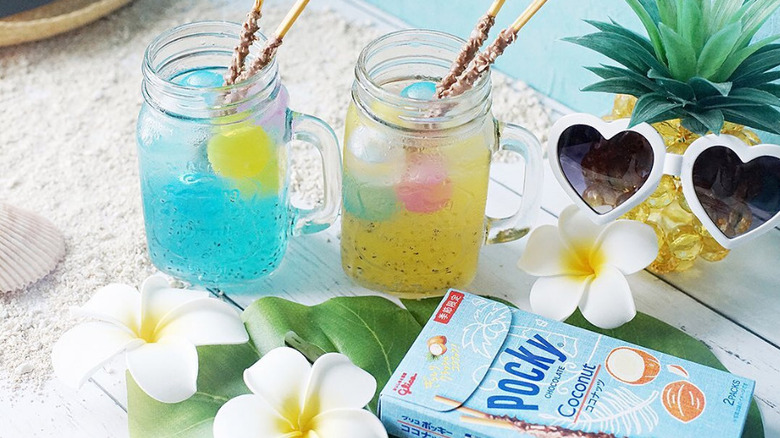 A box of coconut pocky with summery drinks and a pineapple