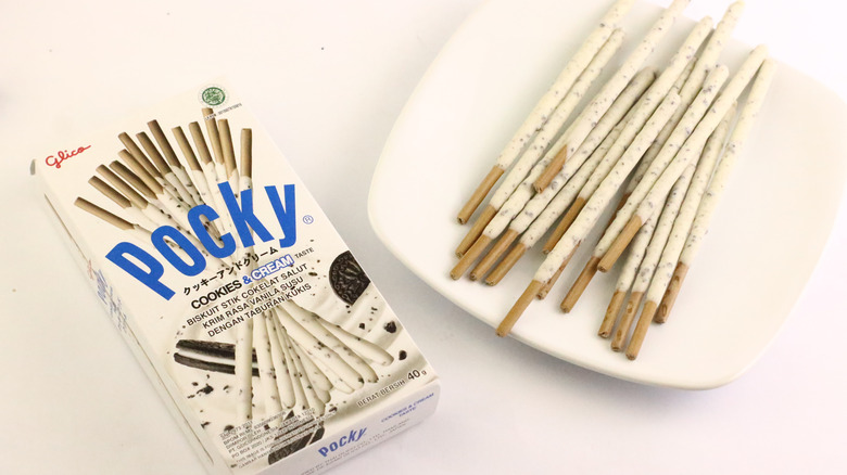 a box of cookies and cream pocky and pocky sticks on a plate