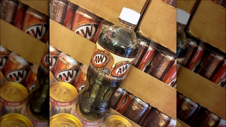 Bottle of A&W Root Beer on top of boxes of cans