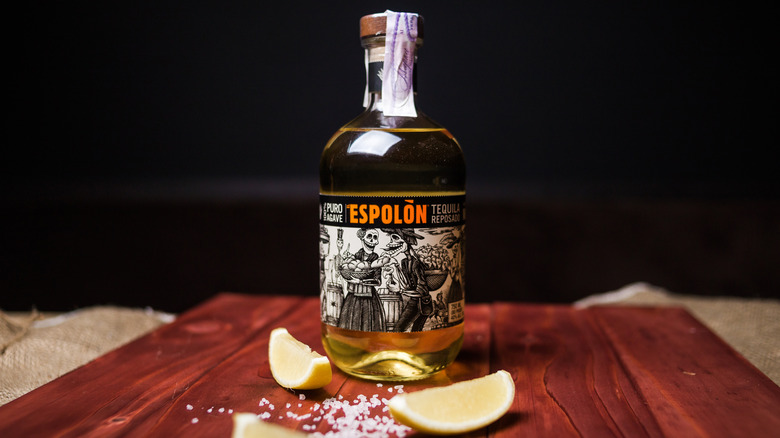 Bottle of Espolon tequila with lime wedges and salt